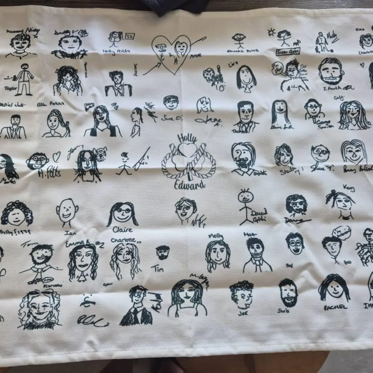 Cream cotton tea towel printed with black ink guest self-portraits